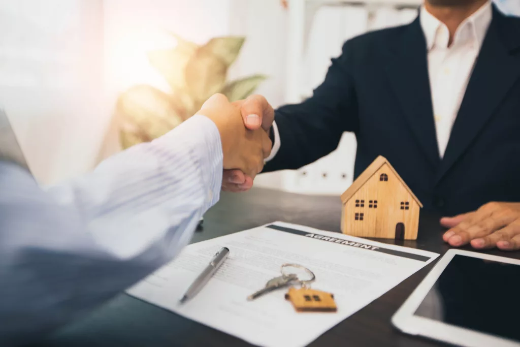 successful negotiate and handshake of buying and selling or real estate concept, home agent shake hand with customer after sign contract and finishes deal purchase house success